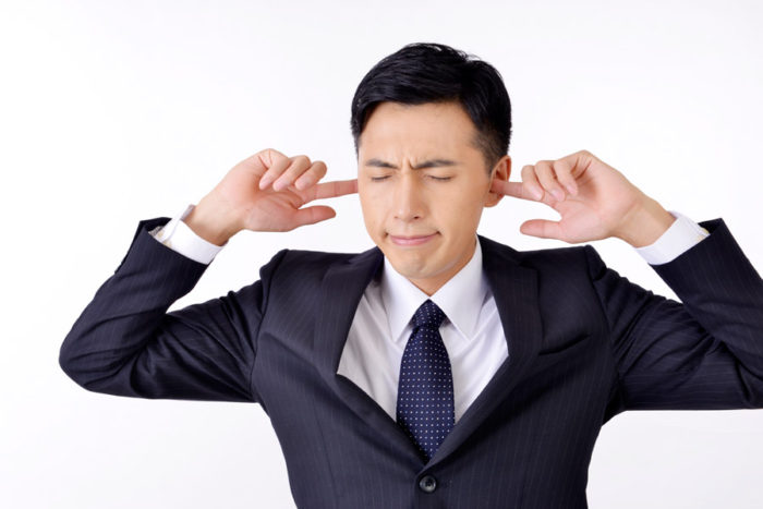 耳に指を突っ込む男性